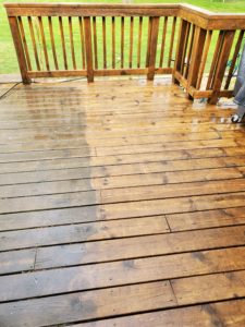 Power washing deck showing half dirty and half clean
